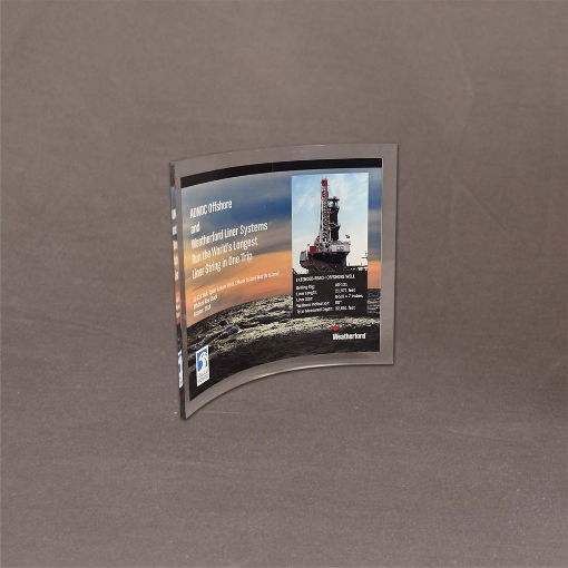 Angled view of small Curved Process Lucite® Plaque featuring offshore oil rig image and full-color print for ADNOC and Weatherford recognition