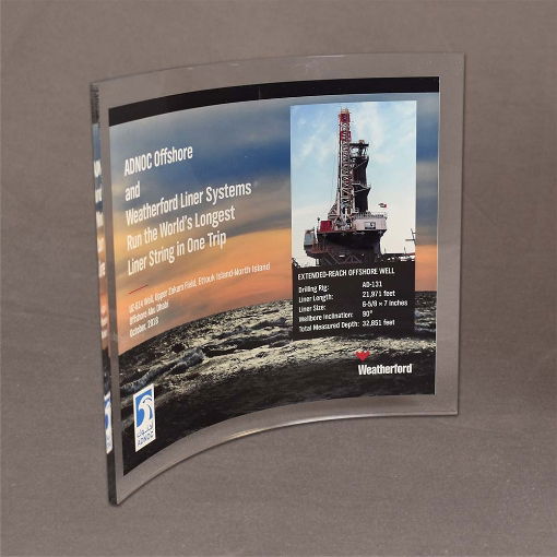 Angled view of Large Curved Process Plaque featuring vibrant oil rig imagery and bold recognition details in a sweeping Lucite® arc