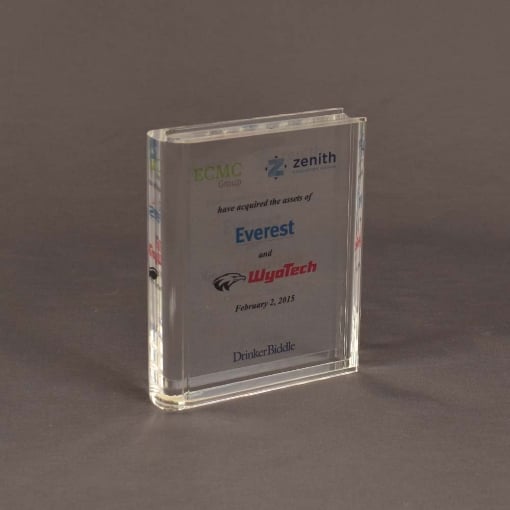 Angled view of small slim book-shaped Lucite® embedment with embedded text and corporate logos in a sleek, compact acrylic form