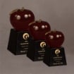 Set of three red Lucite® apples on black bases in small, medium, and large sizes, ideal for tiered award recognition.