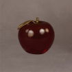 Elegant medium red apple sculpture with a golden leaf, shown at a graceful angle to emphasize its smooth form and glossy surface.