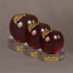 Trio of red Lucite® apples with gold stems on clear round bases, available in three distinct sizes for award or display.
