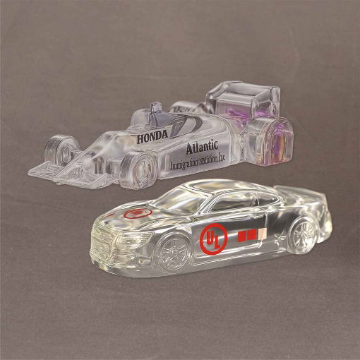 Lucite® embedments shaped as an Indy Car and Stock Car with detailed engraving and custom logos displayed on a neutral background.